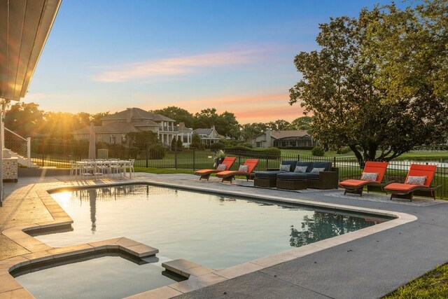 9000 Shawn Park Pl, Orlando, FL 32819 - pool at dusk featuring an in ground hot tub, a fenced in pool, fence, outdoor lounge area, and a patio