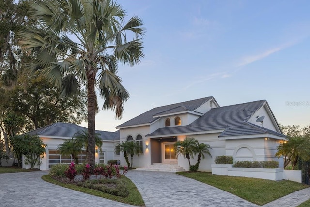 9000 Shawn Park Pl, Orlando, FL 32819 - view of front facade featuring a tile roof, decorative driveway, and an attached garage