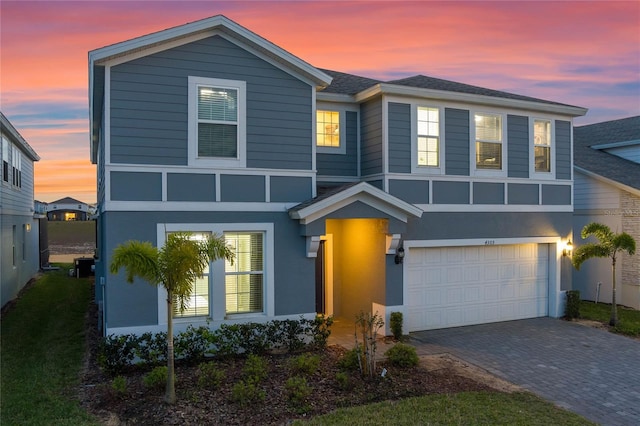 4305 Lana Ave, Davenport, FL 33897 - view of front of home featuring decorative driveway, a garage, and stucco siding