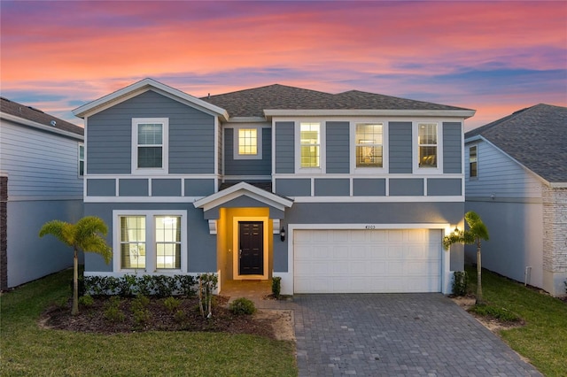 4305 Lana Ave, Davenport, FL 33897 - view of front of home with stucco siding, decorative driveway, a front lawn, a garage, and a shingled roof