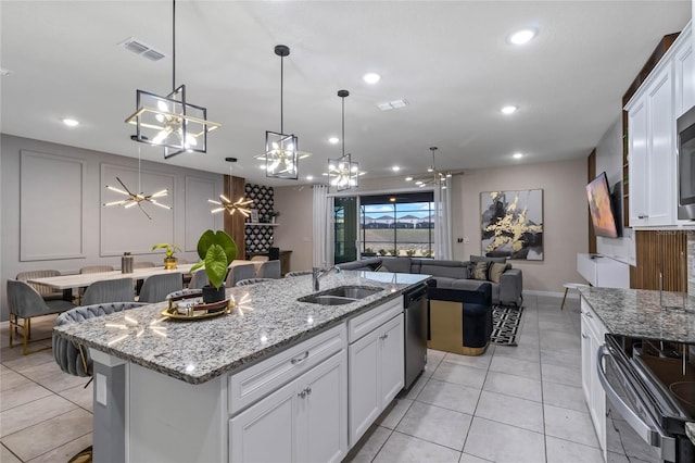 4305 Lana Ave, Davenport, FL 33897 - kitchen featuring a sink, black range with electric stovetop, dishwasher, a center island with sink, and visible vents
