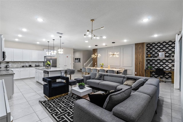 4305 Lana Ave, Davenport, FL 33897 - living area with a textured ceiling, visible vents, light tile patterned floors, and a chandelier