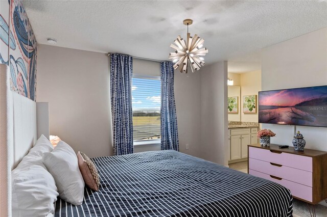 4305 Lana Ave, Davenport, FL 33897 - bedroom featuring a textured ceiling, ensuite bathroom, and a chandelier