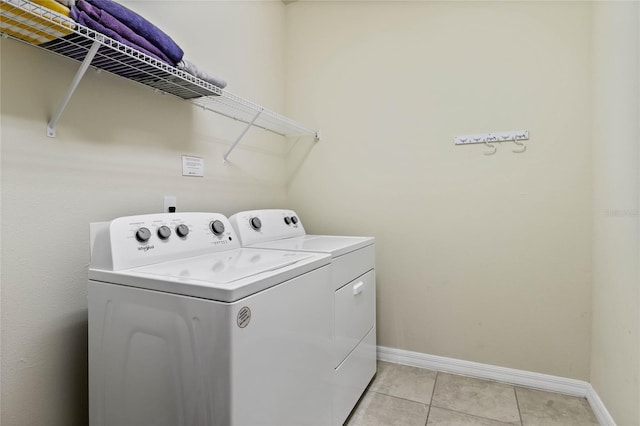 4305 Lana Ave, Davenport, FL 33897 - laundry area featuring light tile patterned floors, washing machine and dryer, baseboards, and laundry area
