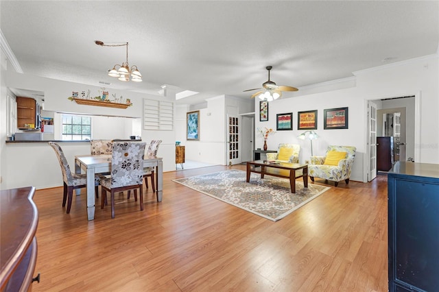 5813 Parkview Point Dr, Orlando, FL 32821 - dining space featuring a textured ceiling, ornamental molding, light wood-type flooring, and ceiling fan with notable chandelier
