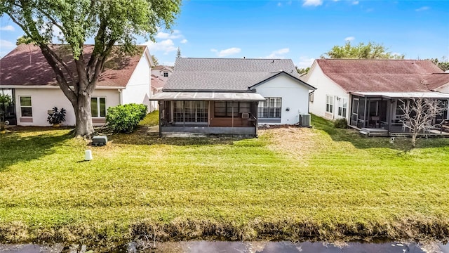 5813 Parkview Point Dr, Orlando, FL 32821 - rear view of property featuring stucco siding, a sunroom, a lawn, a water view, and central AC