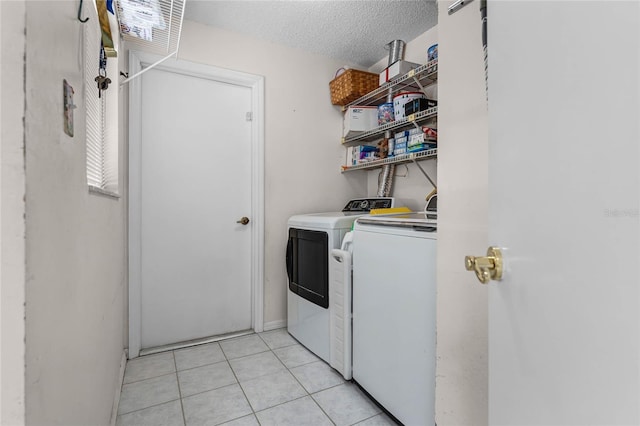 5813 Parkview Point Dr, Orlando, FL 32821 - laundry room featuring light tile patterned floors, a textured ceiling, laundry area, and washer and clothes dryer