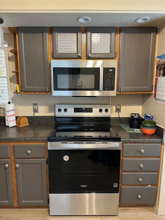 5813 Parkview Point Dr, Orlando, FL 32821 - kitchen with gray cabinetry, dark countertops, open shelves, and stainless steel appliances