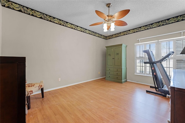 5813 Parkview Point Dr, Orlando, FL 32821 - exercise area with a textured ceiling, light wood-type flooring, and a ceiling fan