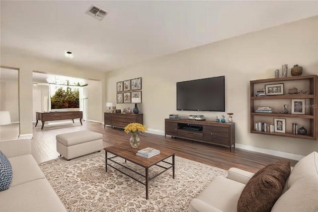 living area with visible vents, wood finished floors, and baseboards