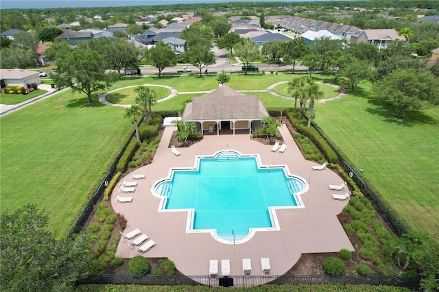 community pool with a patio, fence, an outbuilding, and a yard