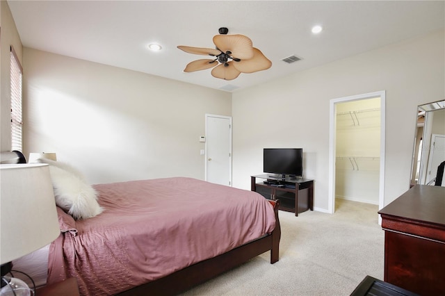 bedroom with a walk in closet, visible vents, light colored carpet, and recessed lighting