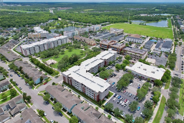 drone / aerial view featuring a water view and a wooded view