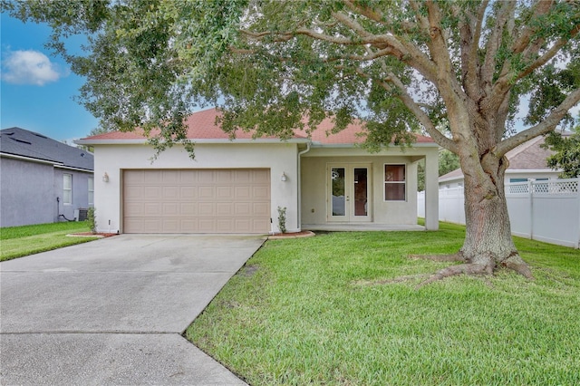 view of front of home with french doors, stucco siding, a front yard, and concrete driveway