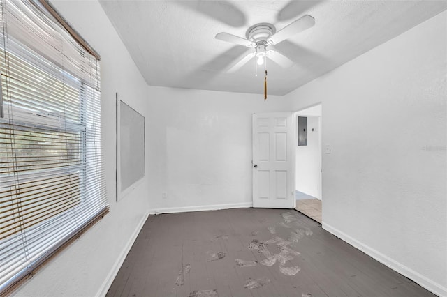 1413 36th St, Orlando, FL 32839 - unfurnished room with a textured ceiling, electric panel, baseboards, wood finished floors, and a ceiling fan