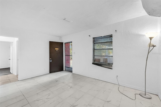 1413 36th St, Orlando, FL 32839 - empty room featuring baseboards, marble finish floor, a textured wall, and visible vents