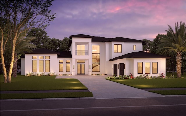 view of front of property with a front lawn, driveway, and stucco siding