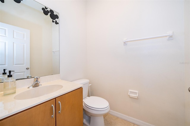 bathroom with toilet, vanity, tile patterned floors, and baseboards