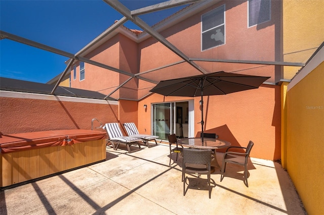 view of patio / terrace featuring a hot tub, outdoor dining space, and a lanai
