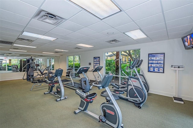 workout area featuring baseboards, visible vents, and a drop ceiling