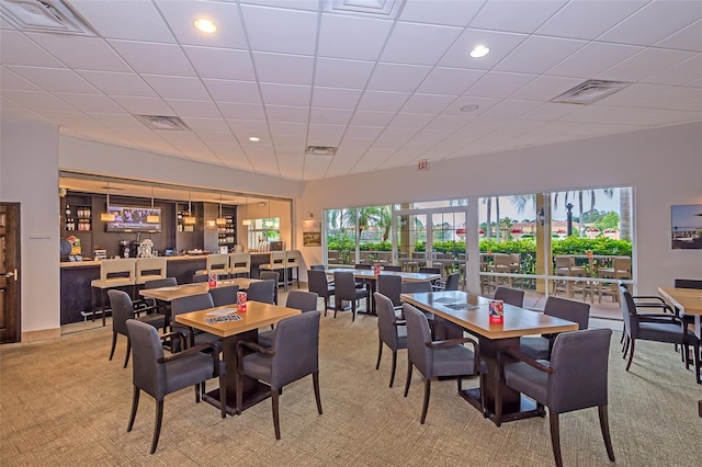 carpeted dining area featuring a community bar, visible vents, and recessed lighting
