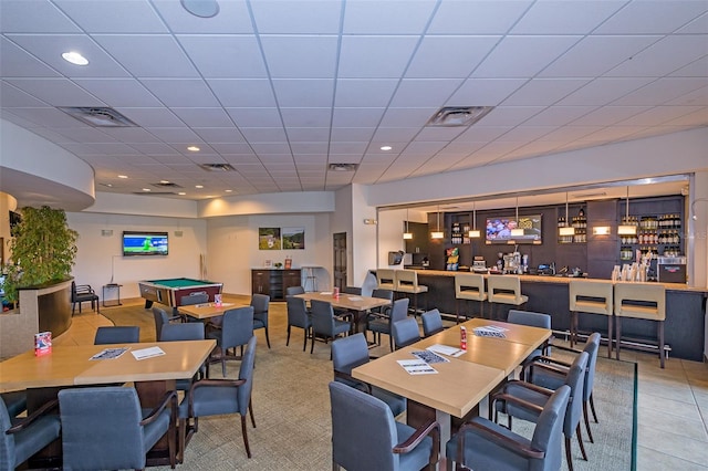 tiled dining space with visible vents and a community bar
