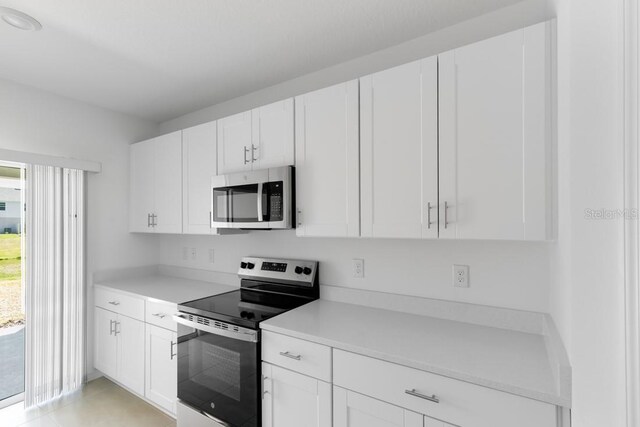 kitchen with light countertops, appliances with stainless steel finishes, and white cabinets