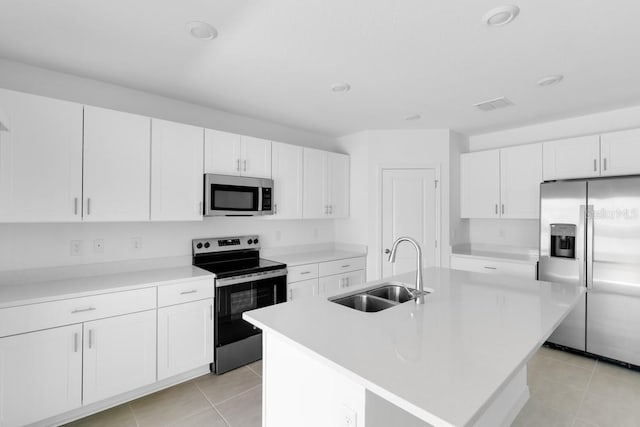 kitchen featuring white cabinets, stainless steel appliances, a sink, and light tile patterned flooring