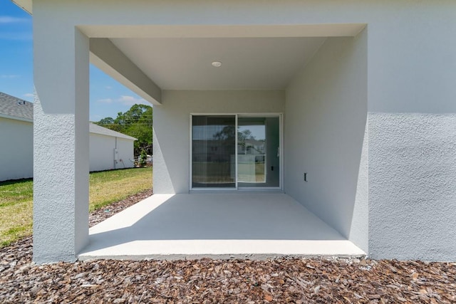 doorway to property with stucco siding and a patio