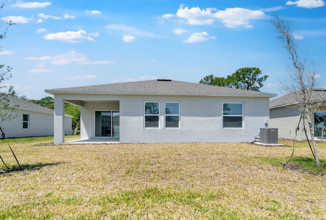 rear view of property with stucco siding, a patio area, a lawn, and central AC unit