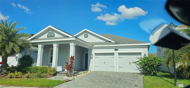 3043 Beaver Creek Dr, Kissimmee, FL 34746 - greek revival inspired property featuring a porch, decorative driveway, an attached garage, and stucco siding
