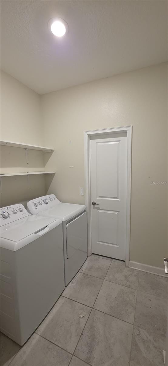 3043 Beaver Creek Dr, Kissimmee, FL 34746 - washroom featuring light tile patterned floors, washer and clothes dryer, laundry area, and baseboards