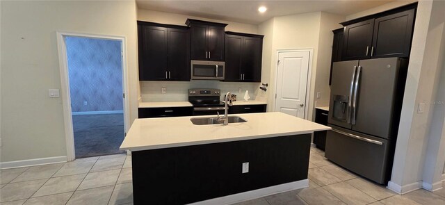 3043 Beaver Creek Dr, Kissimmee, FL 34746 - kitchen featuring appliances with stainless steel finishes, baseboards, light countertops, a kitchen island with sink, and a sink