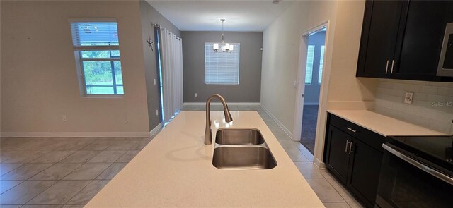 3043 Beaver Creek Dr, Kissimmee, FL 34746 - kitchen featuring dark cabinetry, black electric range oven, a chandelier, a sink, and light tile patterned floors