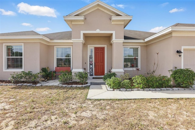 view of front of property featuring stucco siding and a shingled roof