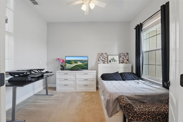 bedroom with a ceiling fan, baseboards, light colored carpet, and visible vents