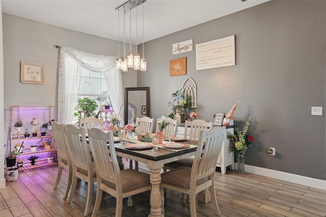 dining area with baseboards and wood tiled floor