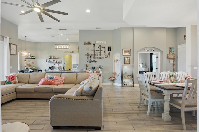 living area with recessed lighting, wood finish floors, arched walkways, visible vents, and ceiling fan