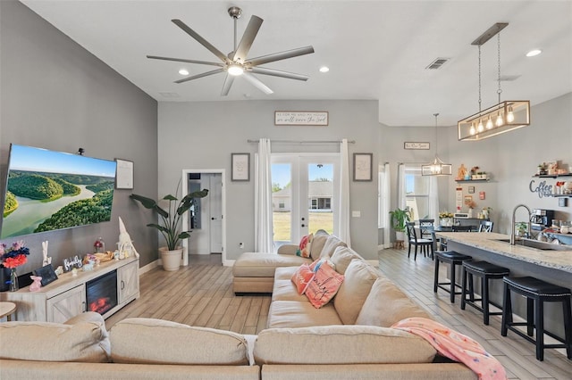 living room featuring light wood-style flooring, recessed lighting, baseboards, visible vents, and a ceiling fan