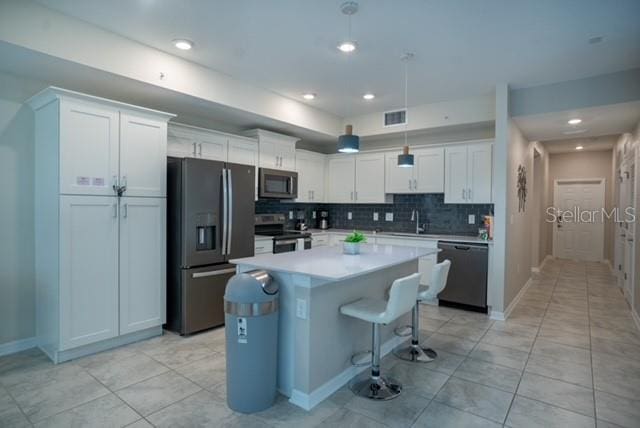 kitchen featuring white cabinets, a sink, appliances with stainless steel finishes, and visible vents