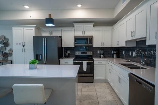 kitchen featuring white cabinetry, decorative backsplash, a sink, and stainless steel appliances
