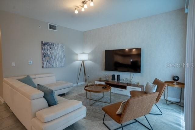 living area with baseboards and visible vents