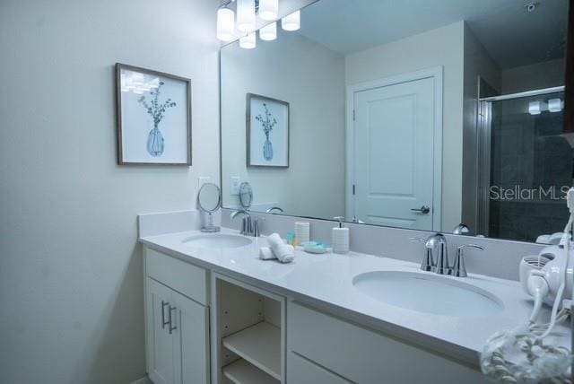 bathroom with double vanity, a sink, and a shower stall