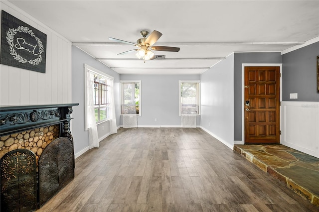 living area with wood finished floors, ceiling fan, a fireplace, and baseboards