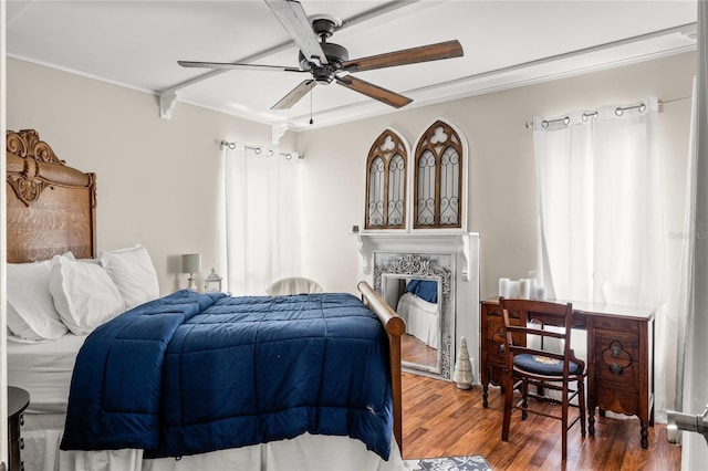 bedroom featuring a premium fireplace, ornamental molding, a ceiling fan, and wood finished floors