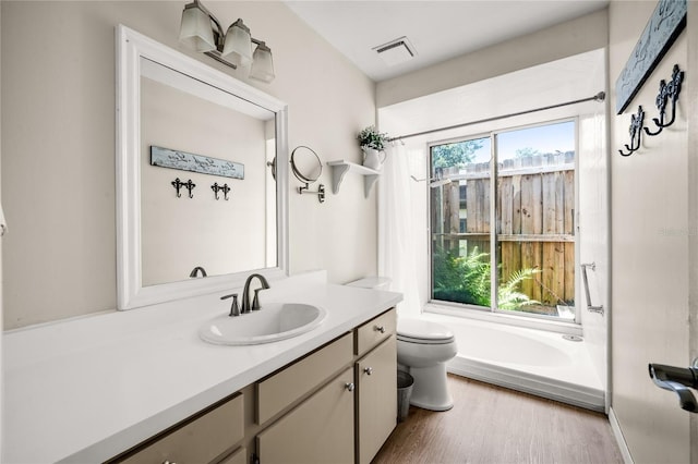 bathroom with visible vents, toilet, vanity, and wood finished floors