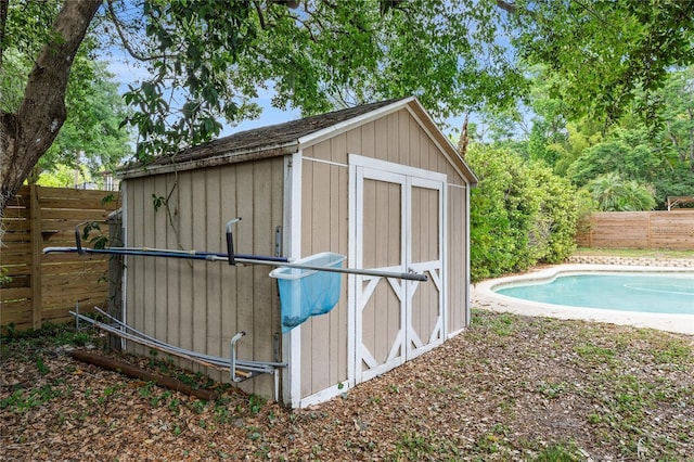 view of shed with a fenced backyard and a fenced in pool