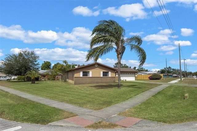 view of front of house with stucco siding, a garage, and a front yard