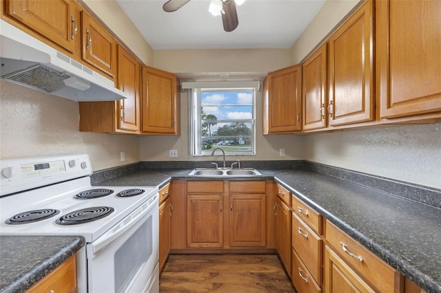 kitchen with white range with electric stovetop, a sink, dark countertops, and under cabinet range hood