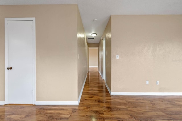 hallway with baseboards and wood finished floors